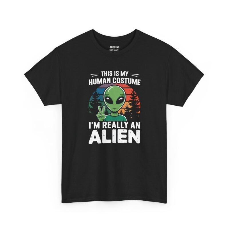 Funny t-shirt with distressed white text reading "THIS IS MY HUMAN COSTUME I'M REALLY AN ALIEN" surrounding a green alien throwing a peace sign in front of a retro striped sunset and dark pine trees, printed on a Black color cotton shirt.