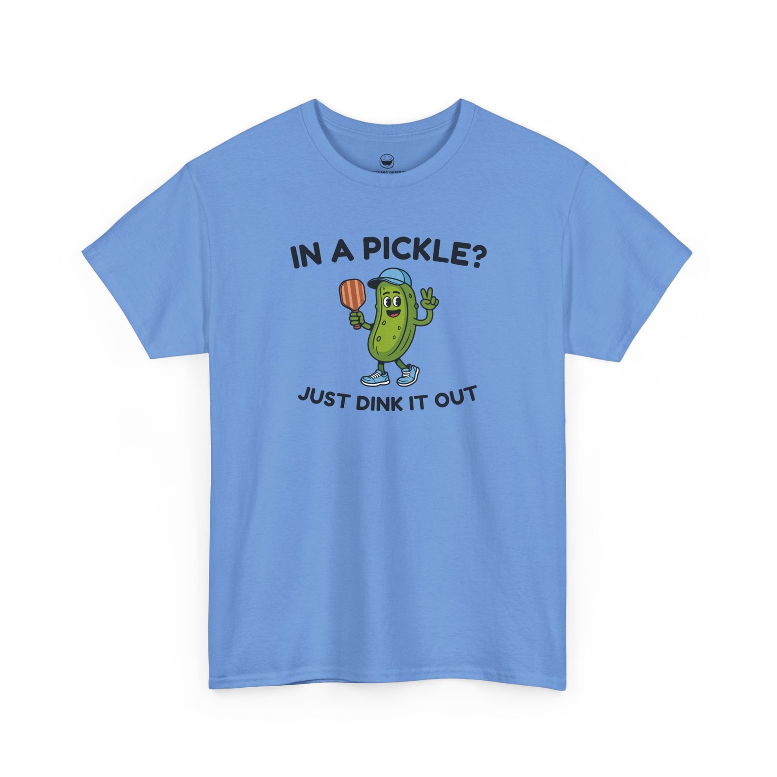 Funny Pickleball T-Shirt with a cartoon pickle character wearing a cap and holding a paddle between text reading "IN A PICKLE? JUST DINK IT OUT", printed on a Carolina Blue color cotton shirt.