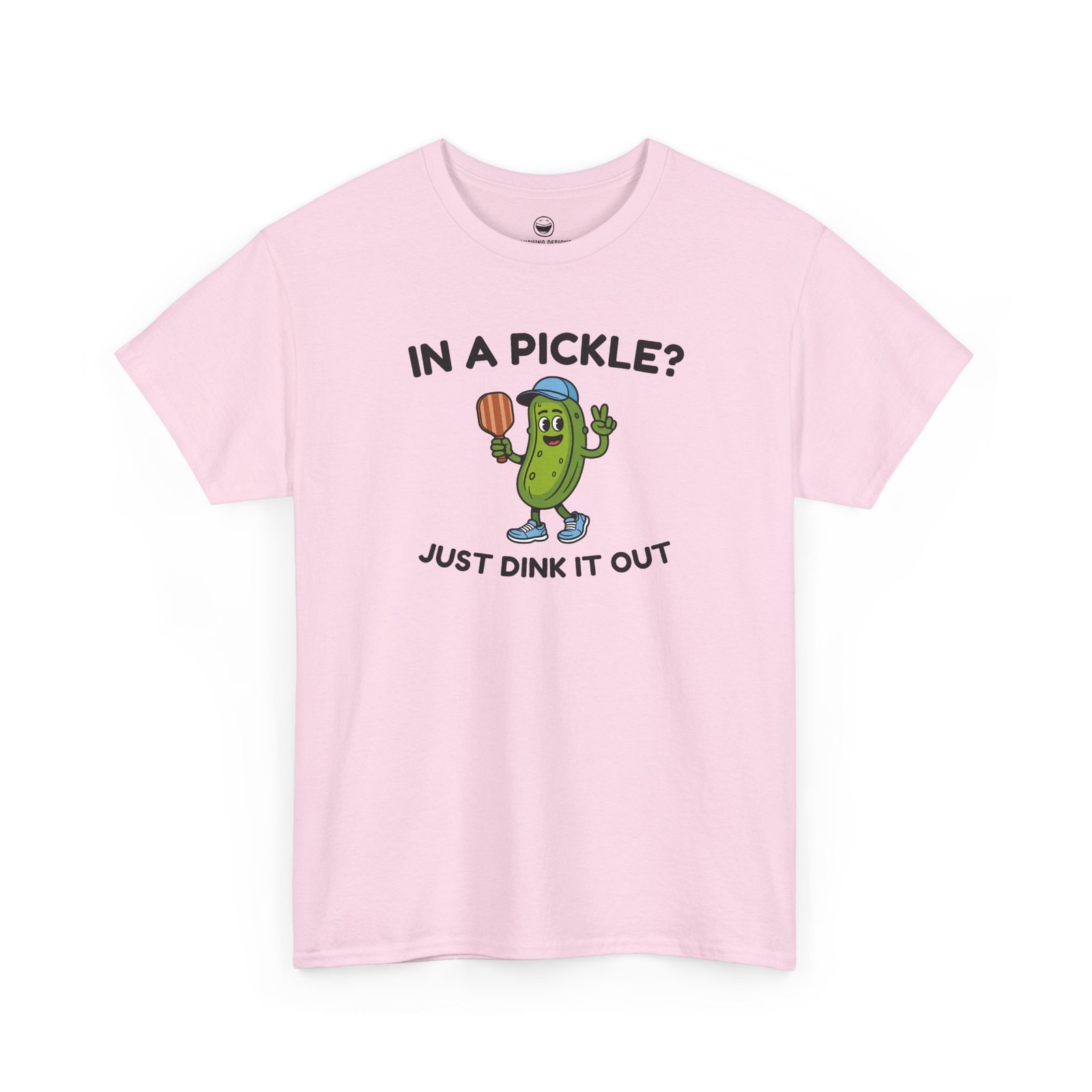 Funny Pickleball T-Shirt with a cartoon pickle character wearing a cap and holding a paddle between text reading "IN A PICKLE? JUST DINK IT OUT", printed on a Light Pink color cotton shirt.