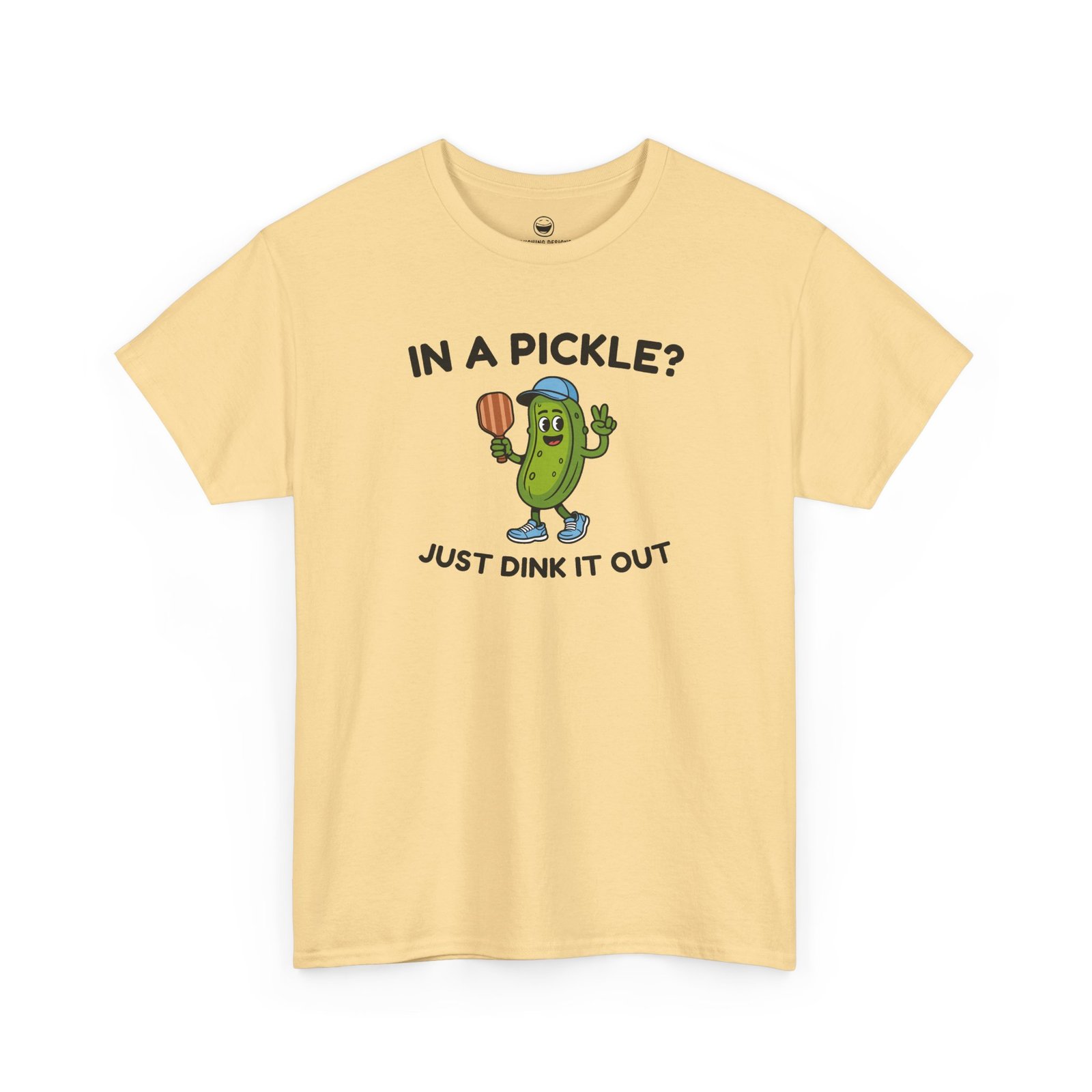 Funny Pickleball T-Shirt with a cartoon pickle character wearing a cap and holding a paddle between text reading "IN A PICKLE? JUST DINK IT OUT", printed on a Yellow Haze color cotton shirt.