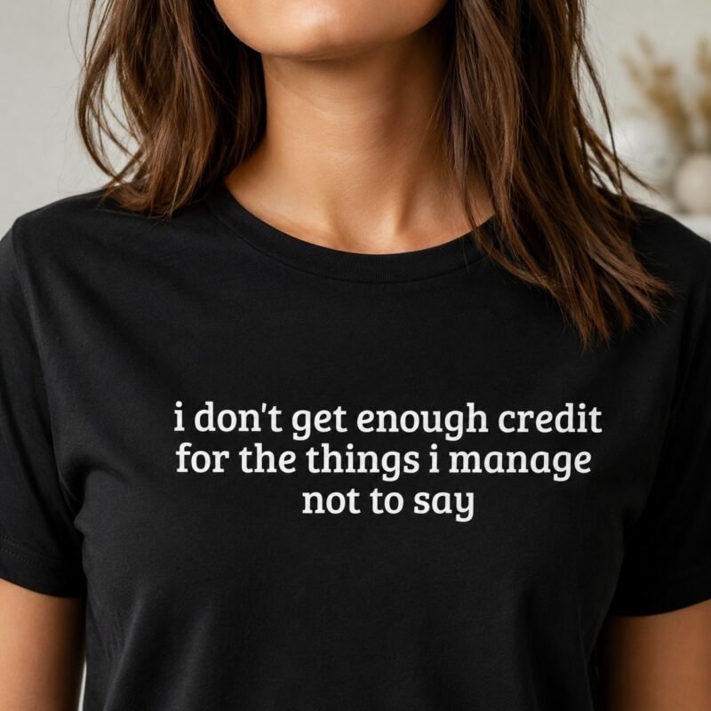 I Don't Get Enough Credit T-Shirt by Laughing Designs, model wearing a black shirt reading i don't get enough credit for the things i manage not to say.