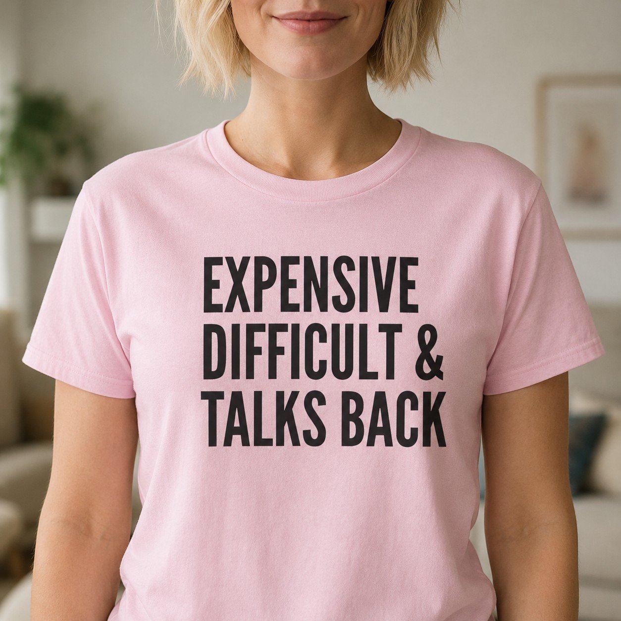Expensive Difficult & Talks Back T-Shirt by Laughing Designs, female model wearing a light pink shirt with bold black typography reading Expensive Difficult & Talks Back.