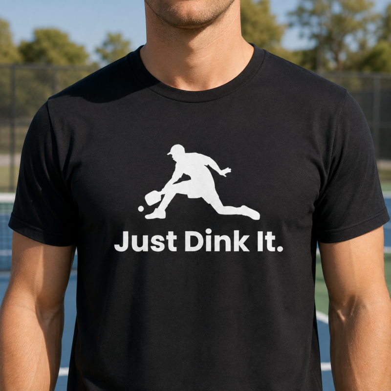 Just Dink It T-Shirt by Laughing Designs, male model wearing a black shirt with white pickleball player silhouette graphic and text reading Just Dink It.