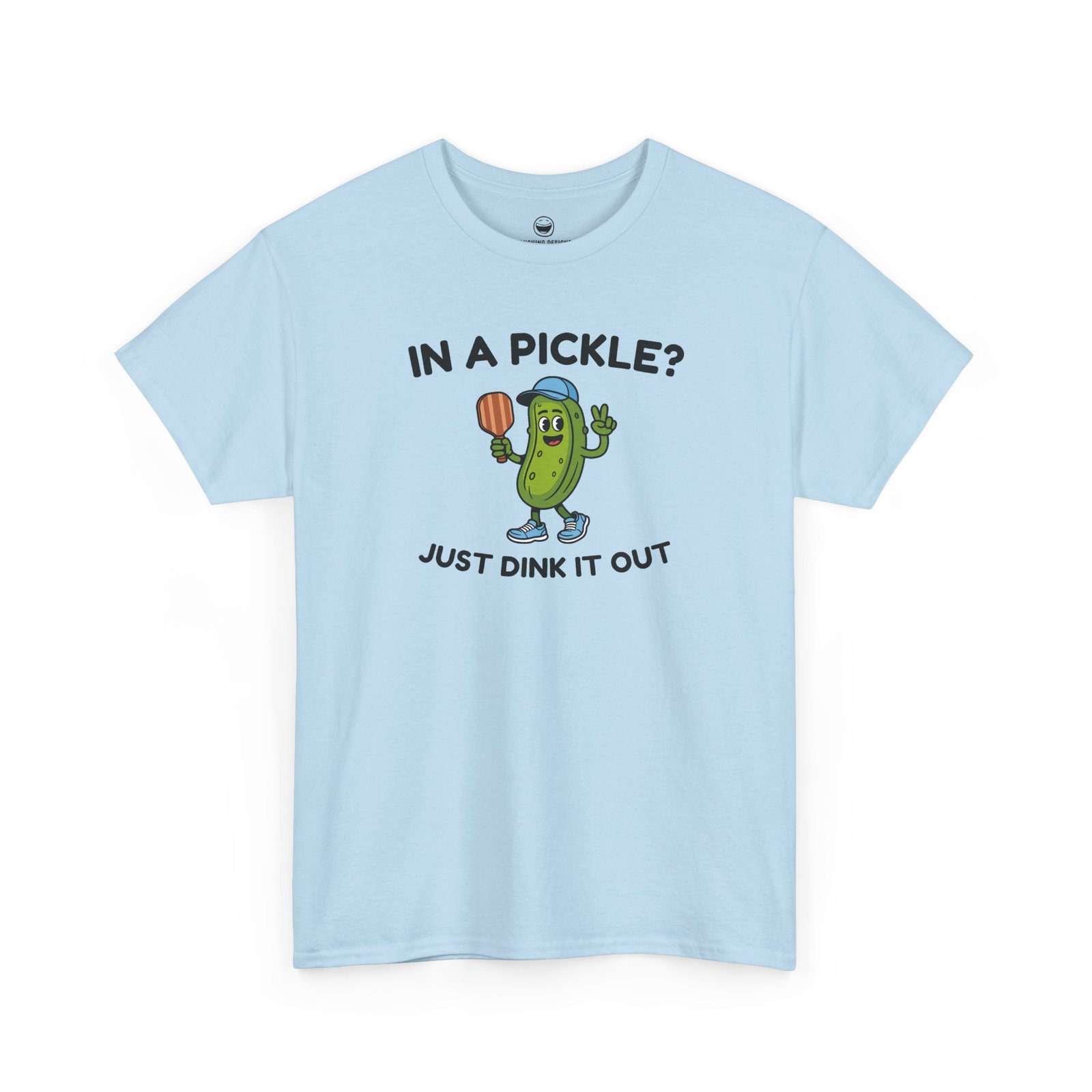 Funny Pickleball T-Shirt with a cartoon pickle character wearing a cap and holding a paddle between text reading "IN A PICKLE? JUST DINK IT OUT", printed on a Light Blue color cotton shirt.